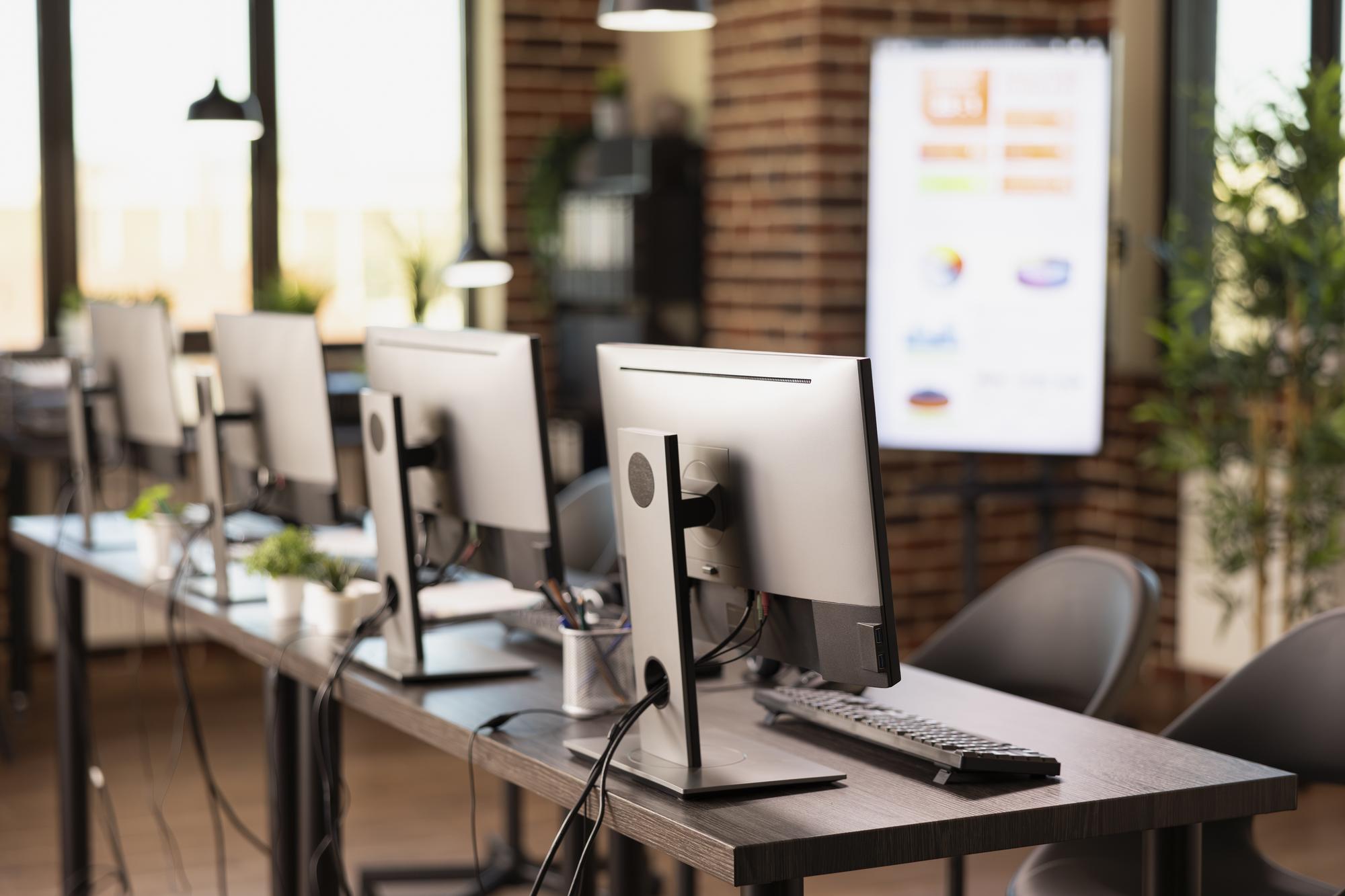 Salle de formation informatique moderne avec plusieurs postes équipés