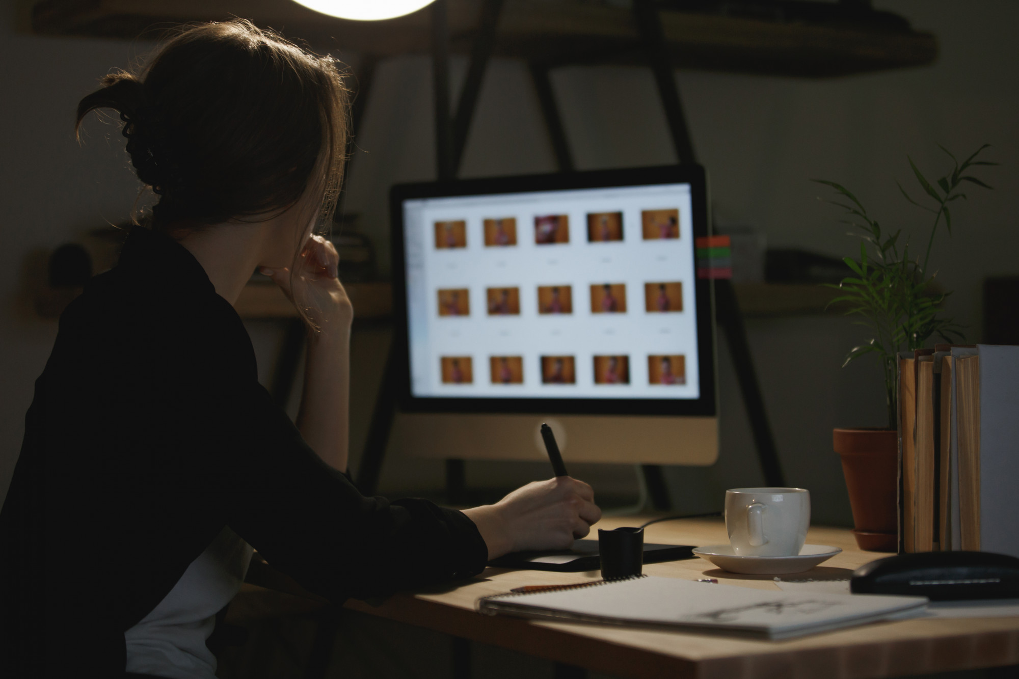 Personne consultant une grille de miniatures de photos sur un écran d'ordinateur