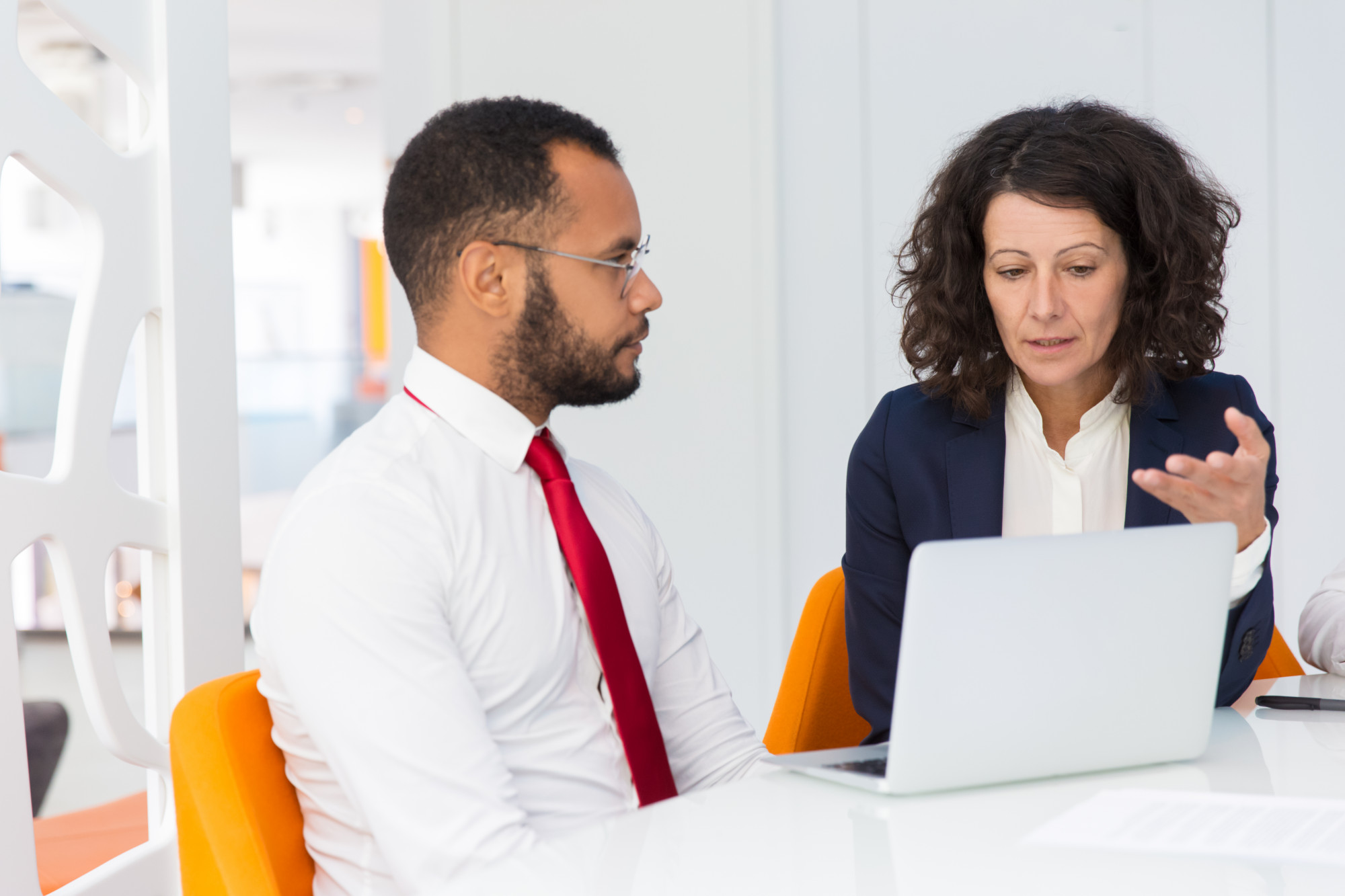 Manager et collaboratrice discutant autour d'un ordinateur portable au bureau