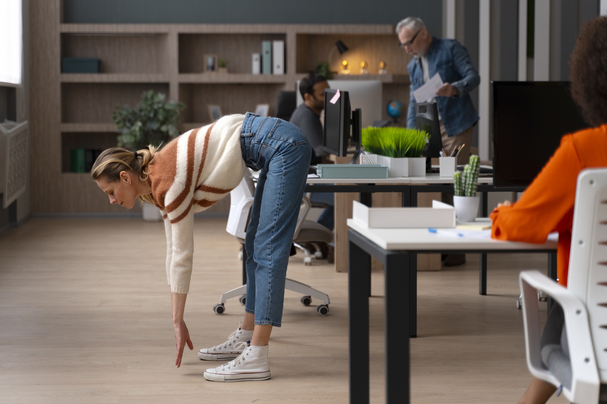 Salariée effectuant des étirements en open space pour prévenir les risques ergonomiques